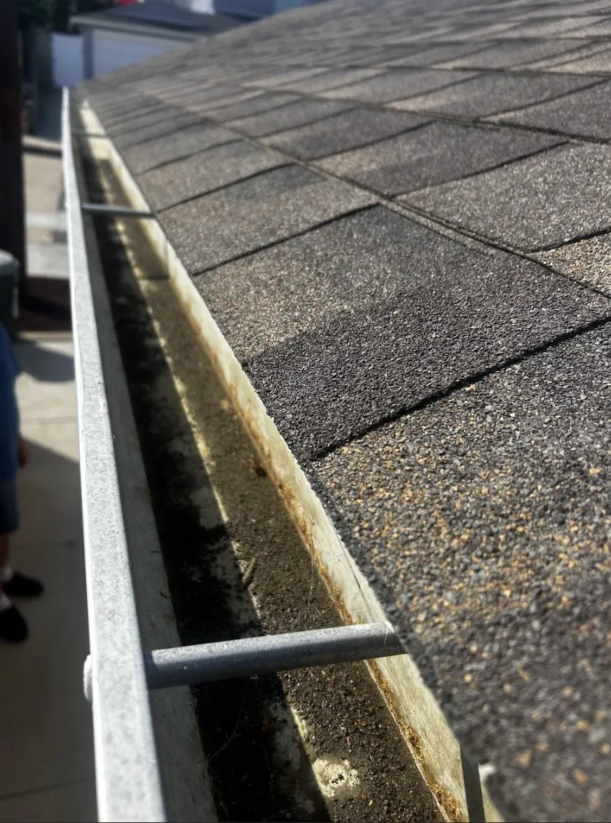 Clogged gutter full of debris before SeaBreeze gutter cleaning in San Diego